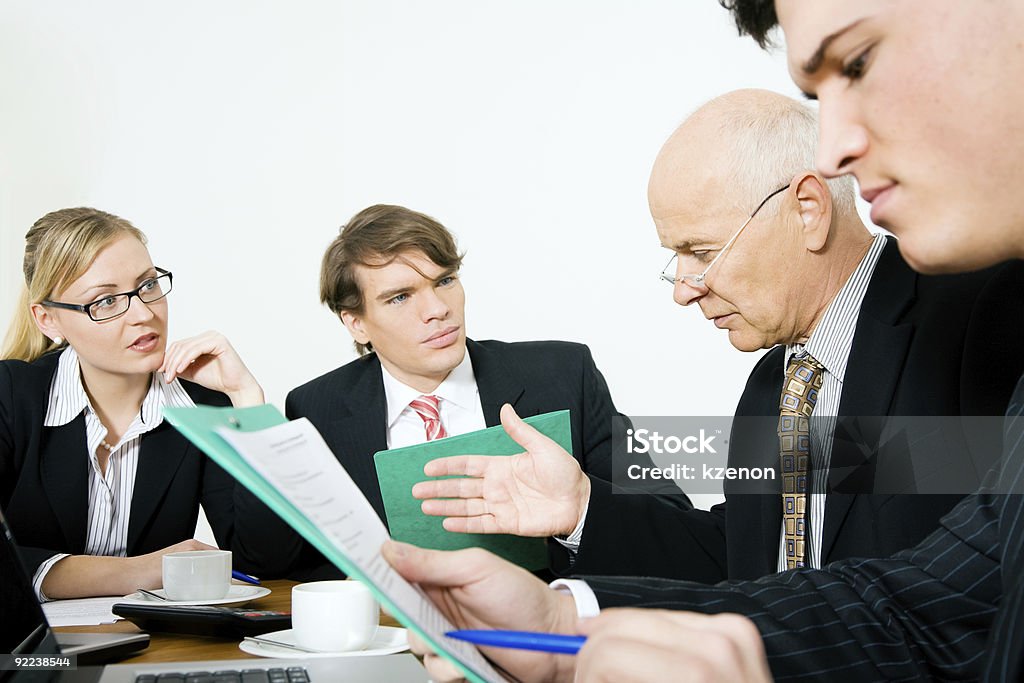 People in suits having meeting around table with white wall Senior Team leader making a decision. Period! (focus only on the senior man!) Adult Stock Photo