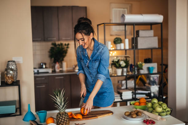 istock Young woman preparing juice from fruit in her kitchen 922387126