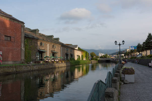 Otaru, Japan - September 1, 2015 : Tourists visiting Otaru Canal in Oraru, Hokkaido, Japan. Many warehouses are on the canal. Otaru Canal is the symbol in Hokkaido. In Meiji Period, Otaru was the significant port in Hokkaido. Nowadays, the canal became a tourist attraction.