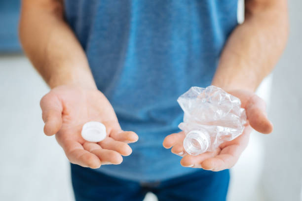 istock Male hands holding a crushed plastic bottle 922387534