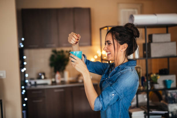 istock Young woman making orange juice in her kitchen 922387636