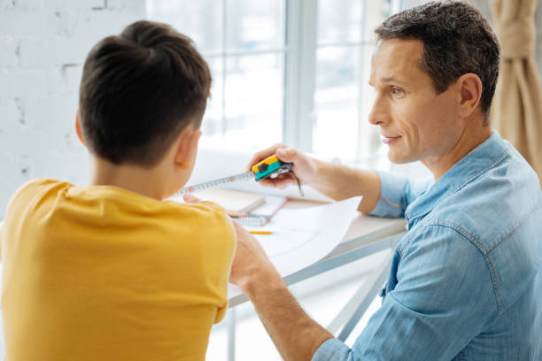 istock Young father showing tape measure to his son 922387748