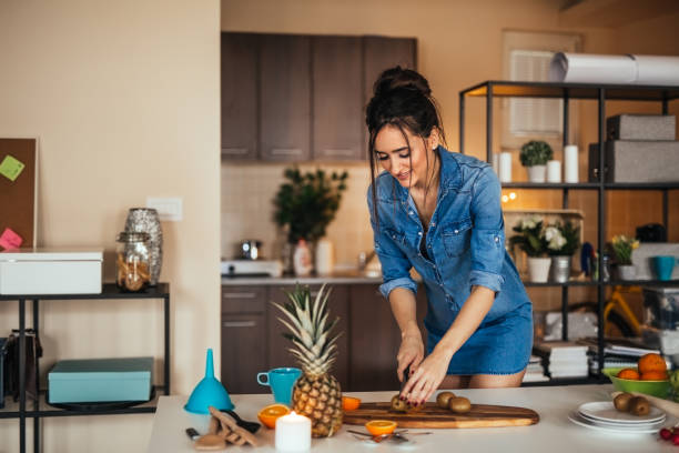 istock Young woman preparing juice from fruit in her kitchen 922387954