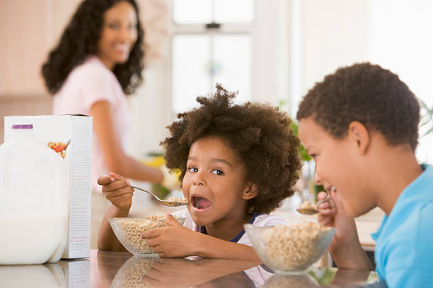 enfants mangeant le petit déjeuner - healthy lifestyle people eating sister photos et images de collection