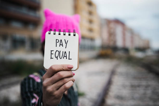 istock woman with a pink hat and the text pay equal 922396982