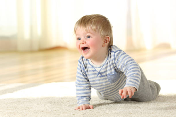 istock Baby crawling and laughing on the floor at home 922400578