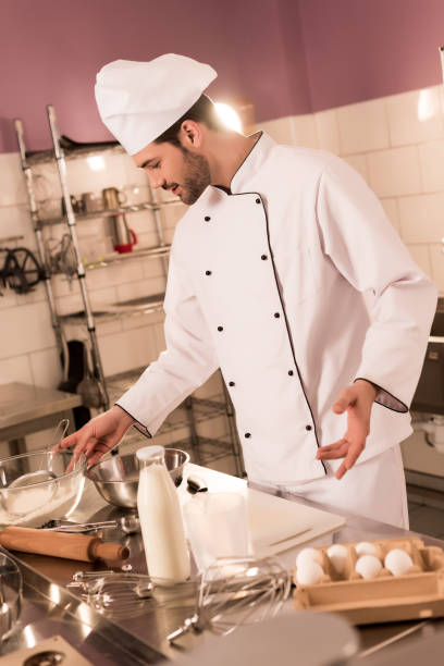 istock confectioner in chef hat making dough in restaurant kitchen 922403930