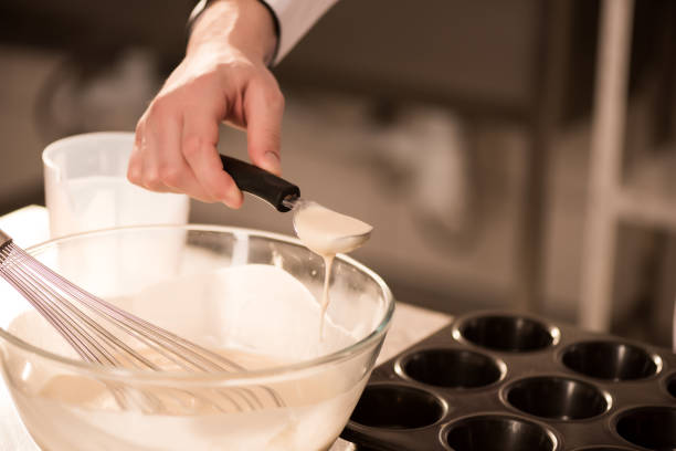 istock partial view of confectioner pouring dough into baking forms 922404084
