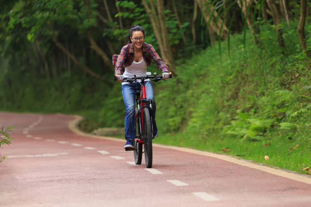 istock cheerful young woman cyclist cycling on forest trail 922404122
