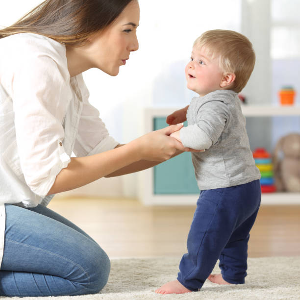 istock Mother helping his son to walk at home 922405084