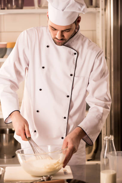 istock focused confectioner in chef hat making dough in restaurant kitchen 922405142