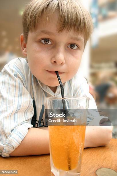 Foto de Criança Tomar Um Refrigerante De Laranja Com Palha e mais fotos de stock de Alimentação Não-saudável - Alimentação Não-saudável, Beber, Bebida