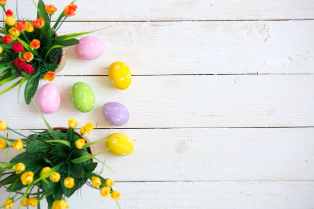istock Easter eggs with flowers on white wooden background 922410942
