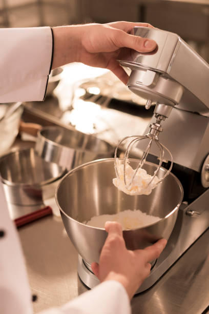 istock partial view of confectioner making cream for dessert in restaurant kitchen 922411560