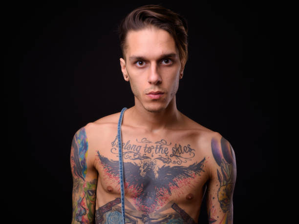 istock Shirtless Handsome Tattooed Man Against Black Background 922414088
