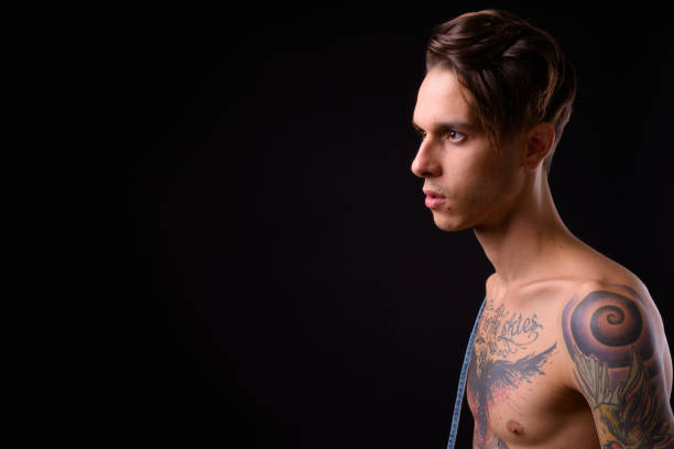 shirtless handsome tattooed man against black background - tattoo men profile punk imagens e fotografias de stock