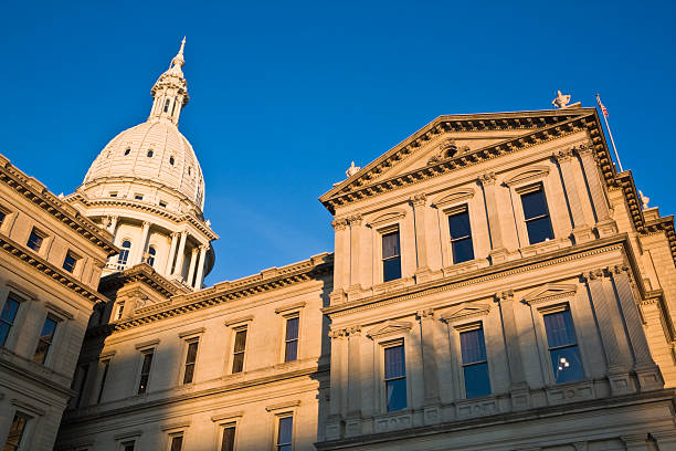 Daylight horizontal view of Michigan State capitol building in Lansing, MI isolated on white sky
