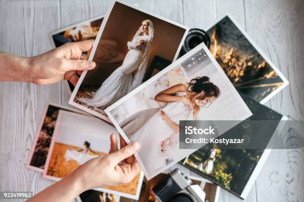 Printed Wedding Photos With The Bride And Groom A Vintage Black Camera And Woman Hands With Two Photos Stock Photo - Download Image Now