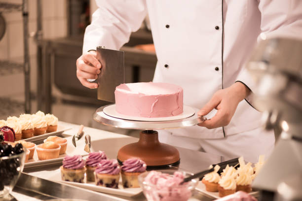 istock cropped shot of confectioner making cake in restaurant kitchen 922420394