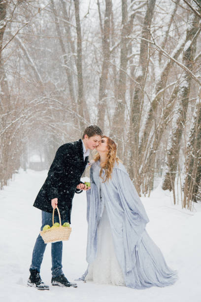 Young loving couple on nature in winter during a snowfall. Wedding day. Toning.