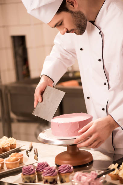 istock focused confectioner making sweet cake in restaurant kitchen 922421180