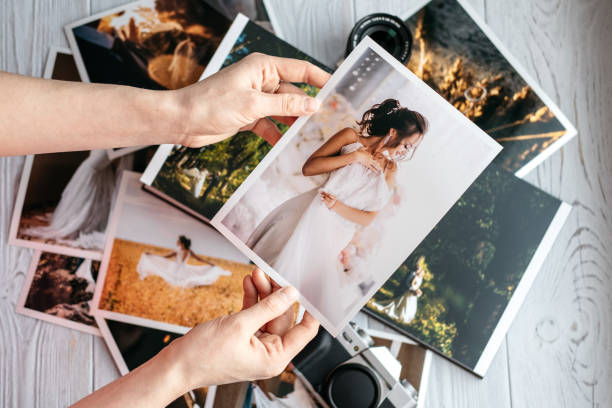 写真花嫁および新郎、ヴィンテージ黒のカメラと女性の手で印刷された結婚式の写真 - 人体部位 写真 ストックフォトと画像