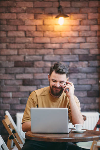 istock Man using laptop and smart phone while sitting in cafe. New technologies concept 922425092