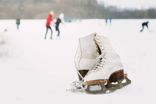 A pair of white retro ice skates on the snow. stock photo