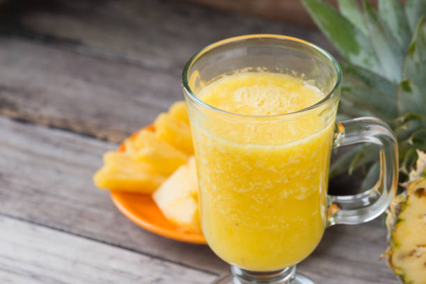 istock Pineapple smoothie  on wood background 922428072
