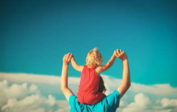 istock father and daughter on shoulders play at sky 922428506
