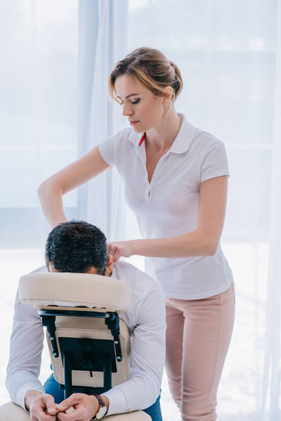 istock attractive masseuse doing shoulders massage on seat at office 922429214