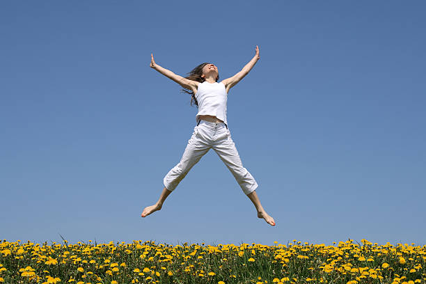 istock Smiling girl jumping in flowering meadow 92243277