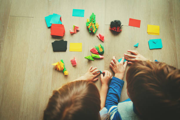 istock kids making origami crafts with paper 922433676