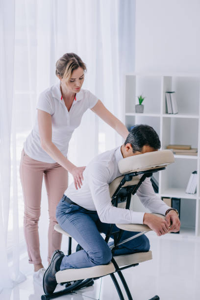 istock masseuse doing back massage for businessman at office 922434080