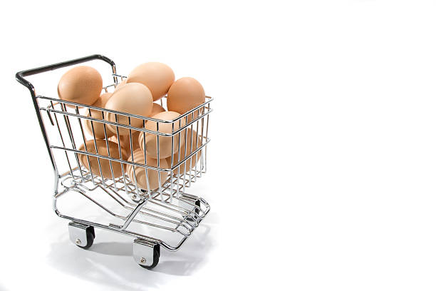 Eggs in Small Shopping Cart on White Background stock photo