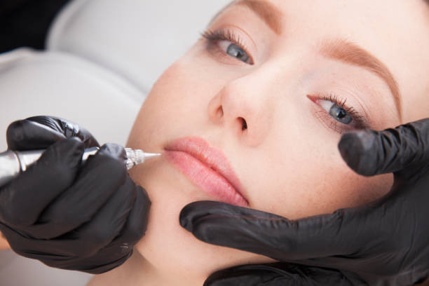 Close up on beautician doing a permanent make up of lips. Permanent make up for lips. permanent marker photos stock pictures, royalty-free photos & images