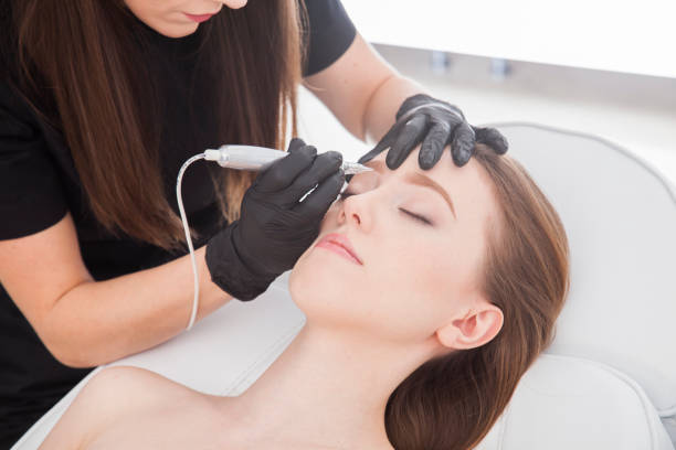 istock Close up on beautician doing permanent make up of eyebrows. 922447838