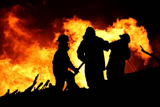 Fire fighters and huge flames stock photo