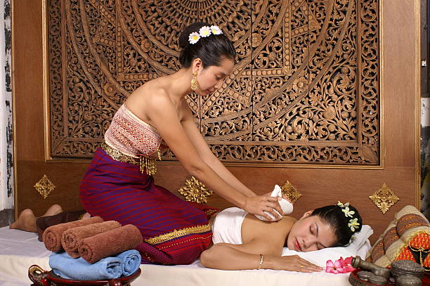 A Thai masseuse giving a massage to a woman stock photo