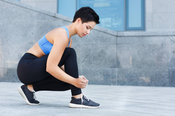 istock Woman tying shoes laces before running 922487084