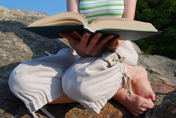 Young woman reading a book outside
