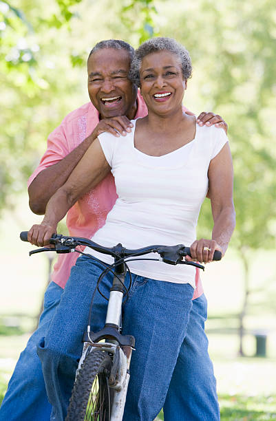 pareja senior en ciclo paseo en - senior adult healthy lifestyle exercising cycling fotografías e imágenes de stock