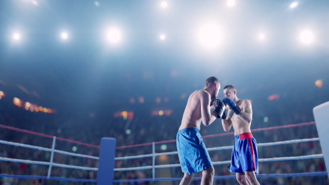 Two male boxers fight on the rink