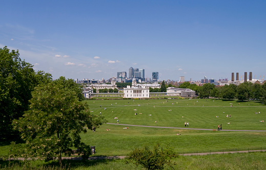 The National Maritime Museum, former Royal Naval College and the Queen's House at Greenwich beyond Greenwich Park, with Canary Wharf and the East End across the River Thames. The Millennium Dome and Greenwich Power station are on the right.