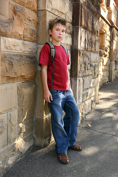 istock Youth leaning against sandstone wall 92251098