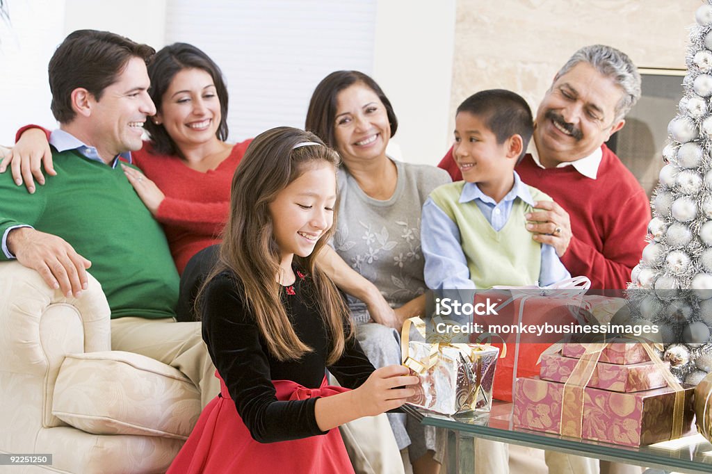 Family Sitting On Sofa In Front Of Christmas Presents  Christmas Stock Photo