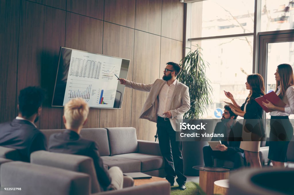 Business presentation Business team on a morning briefing; business meeting and presentation in a modern office Presentation - Speech Stock Photo