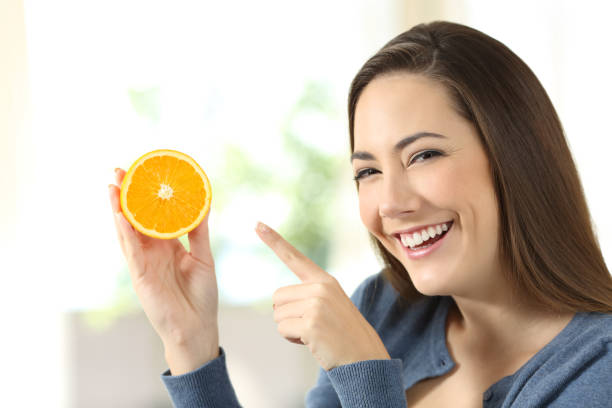 istock Woman showing half orange slice 922518646