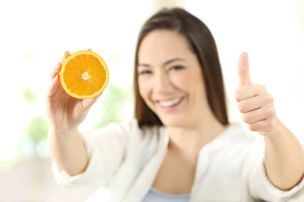 istock Woman showing half orange with thumbs up 922518814