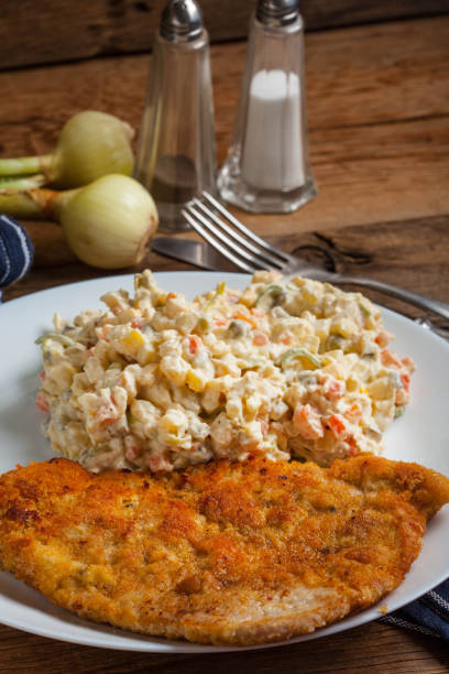istock Fried pork chop in breadcrumbs, served with vegetable salad. 922522826